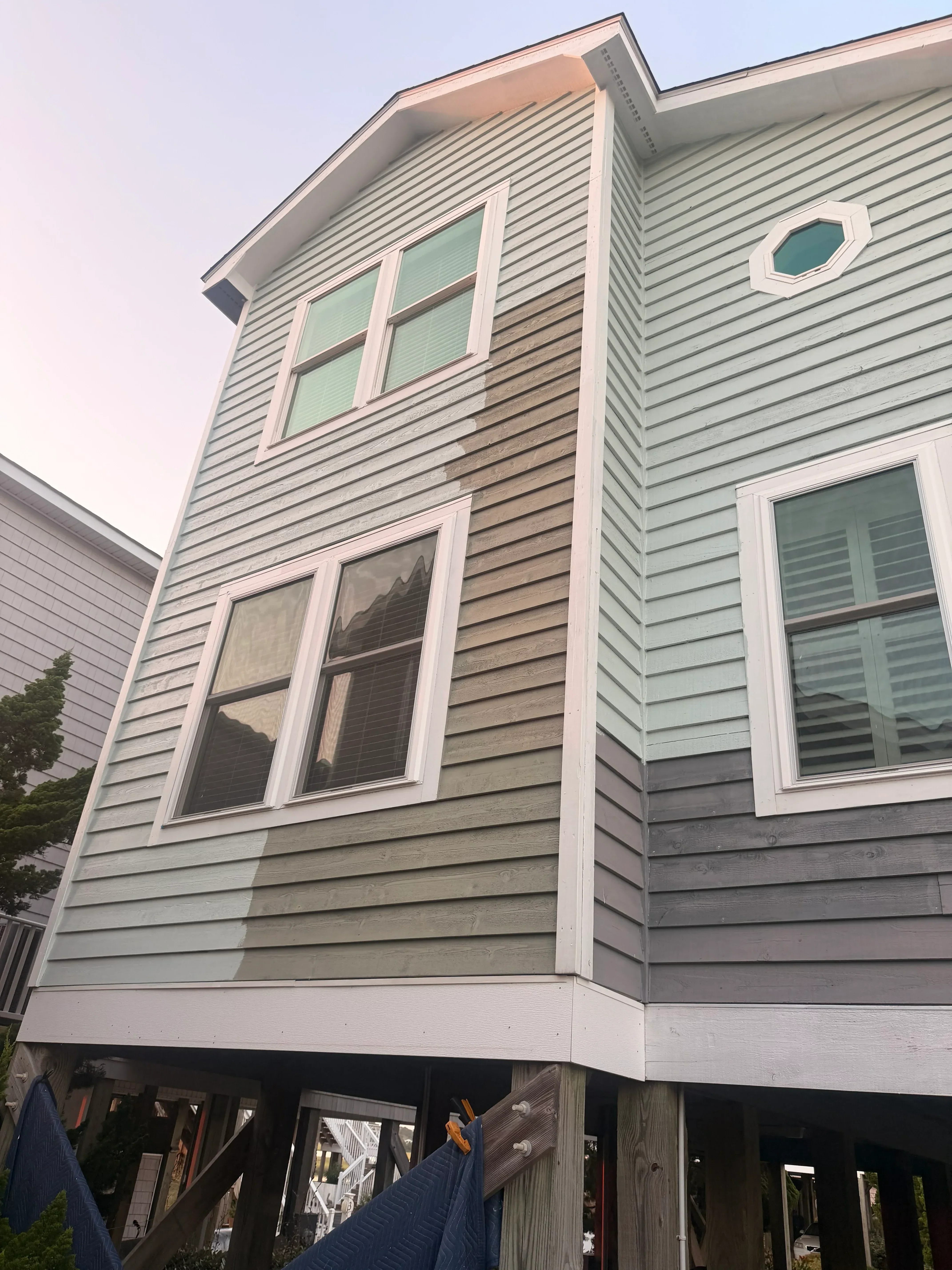 Vertical corrugated metal siding with white-trimmed windows and fascia