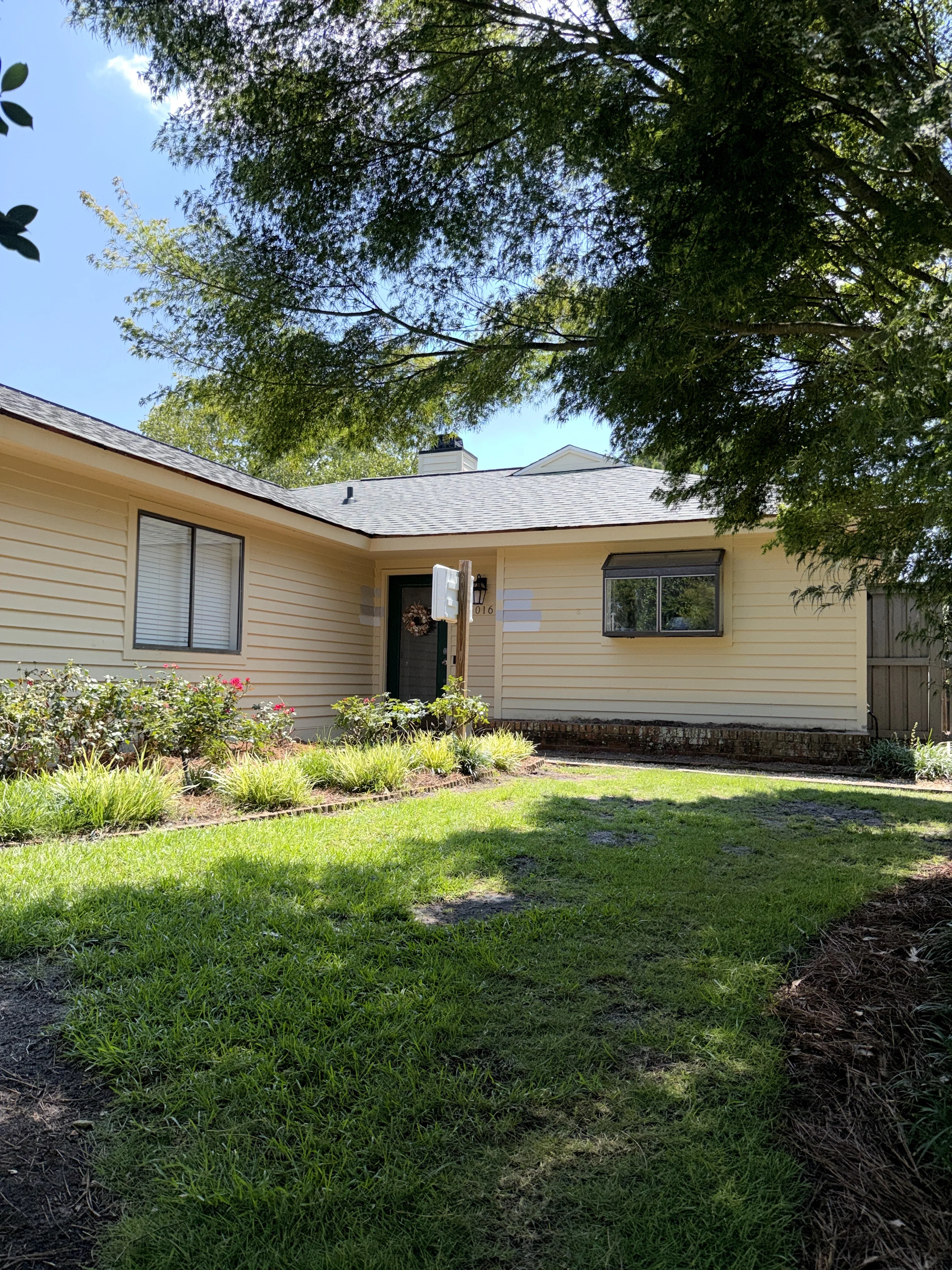 Front yard with new landscape beds, mulch borders, ornamental grasses, and flowering shrubs