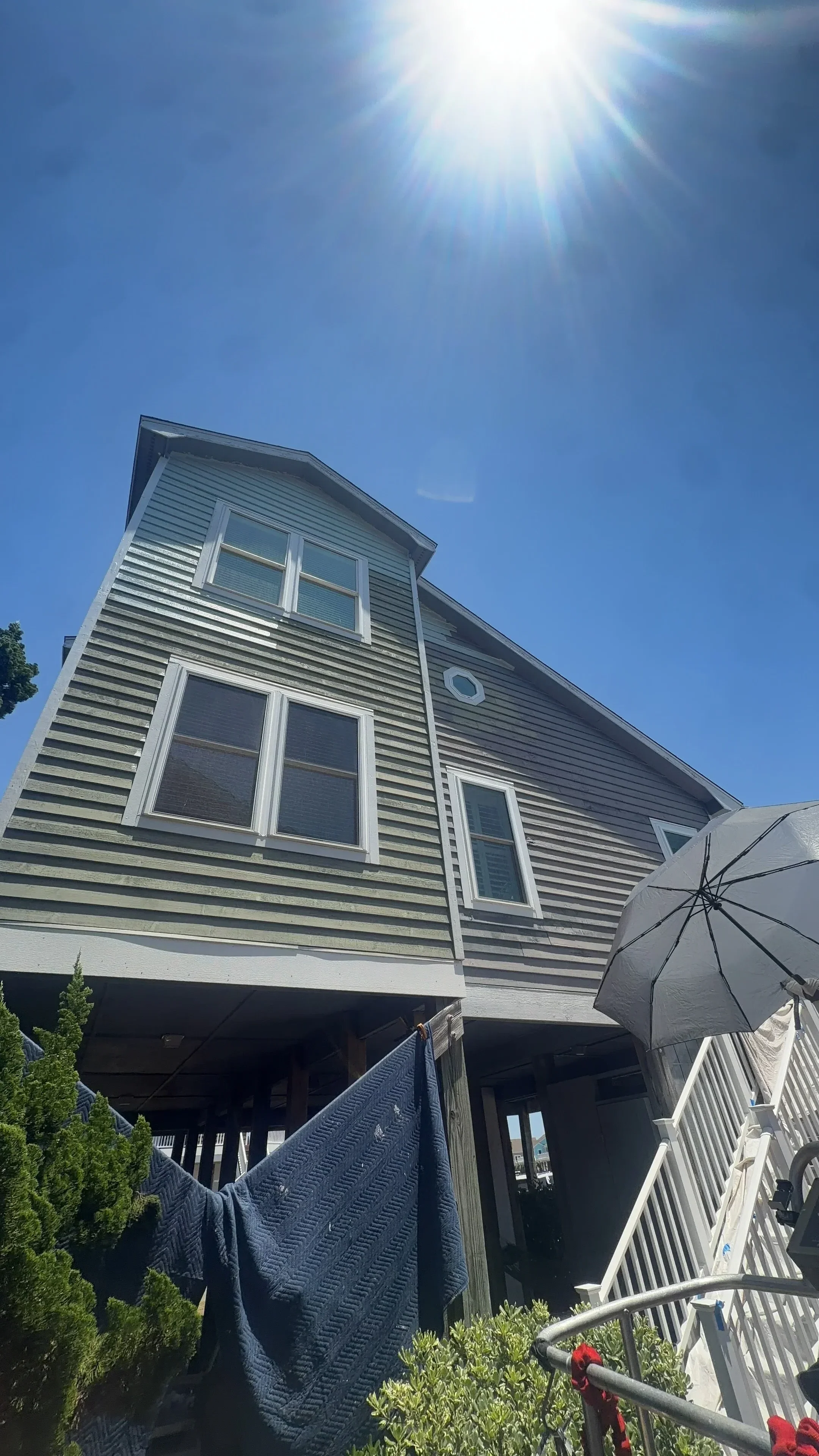Vertical corrugated metal siding with white aluminum pergola and deck framing