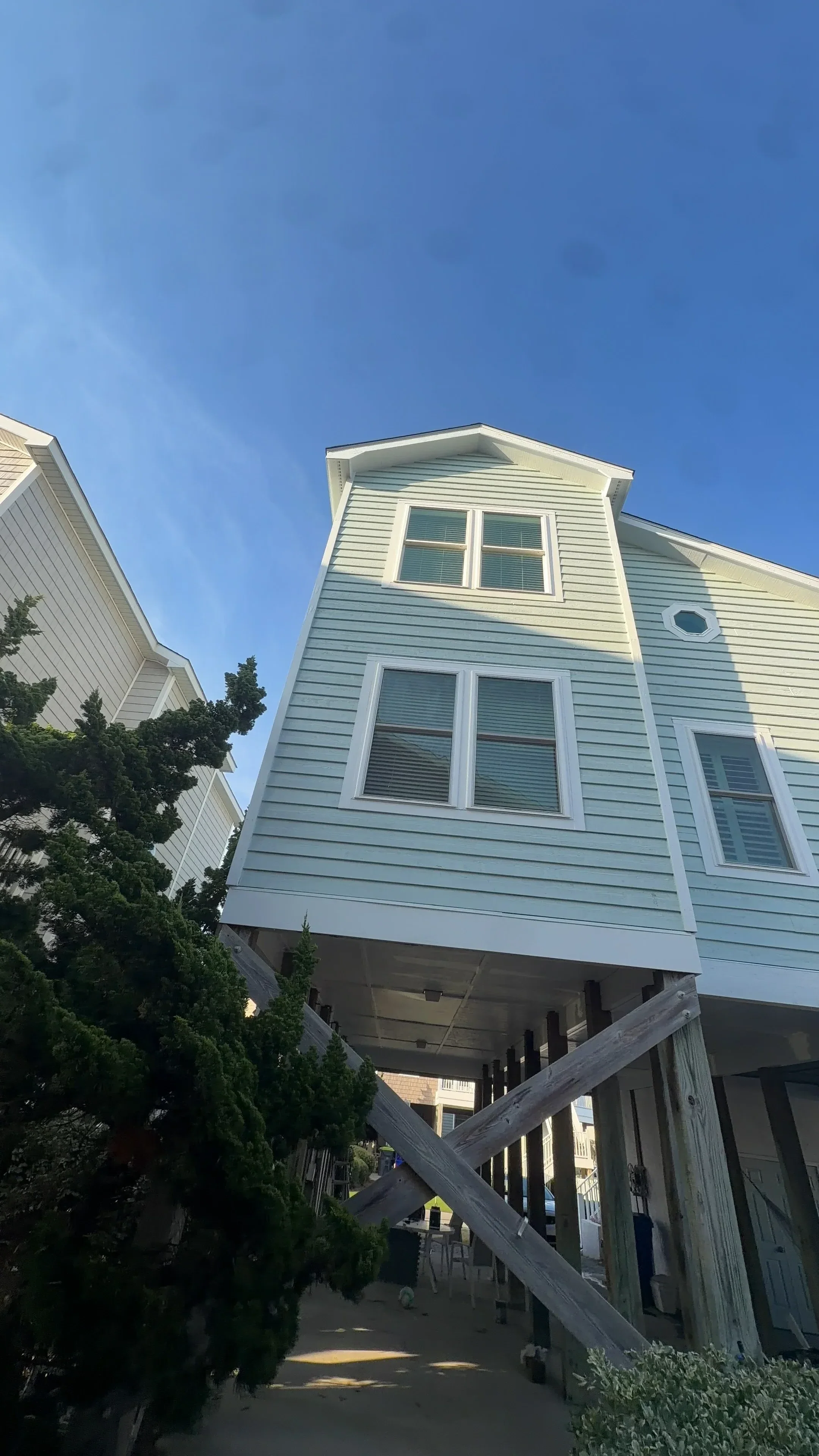 Vertical metal siding with white-framed windows and integrated trim on residential exterior