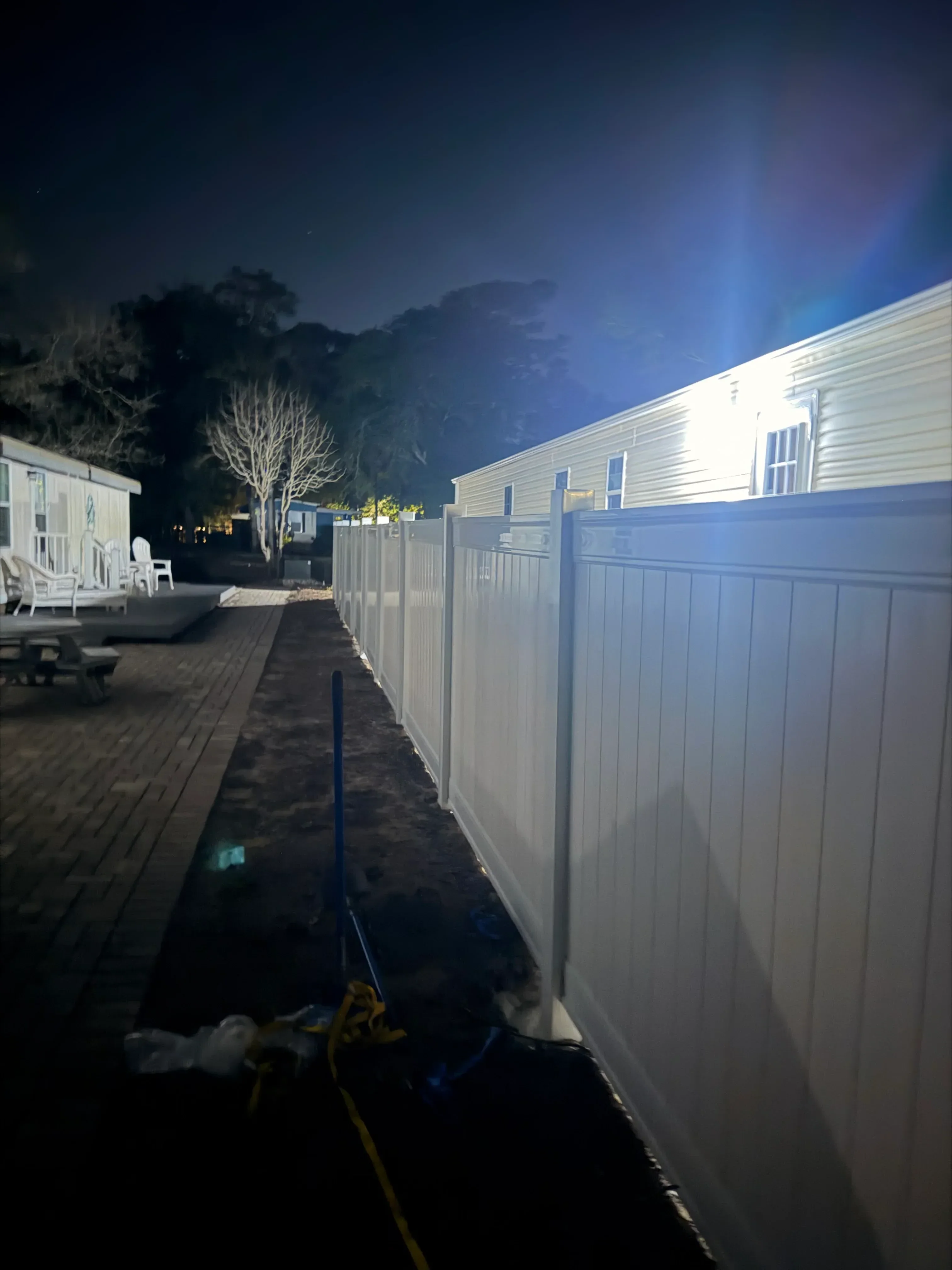 Dark wood privacy fence with horizontal boards installed along residential property line