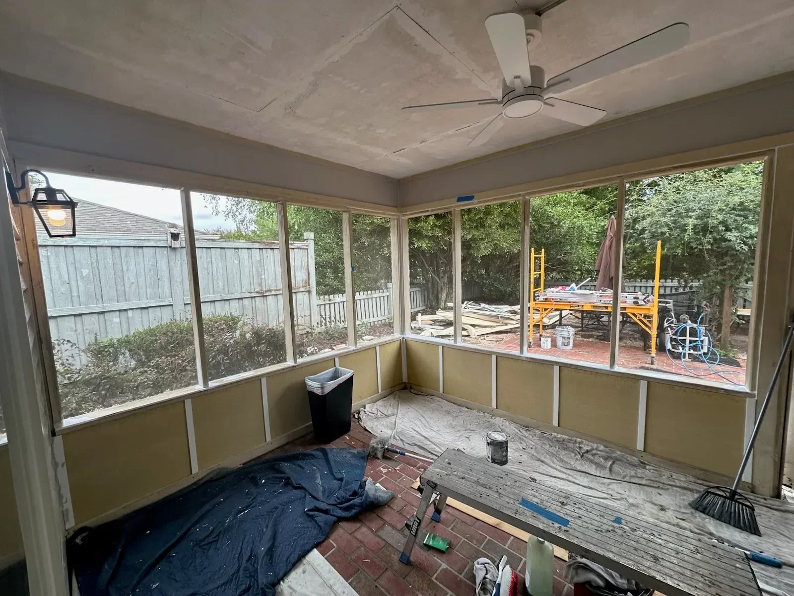 Sunroom interior with aluminum frame windows, tan panels, and drywall construction