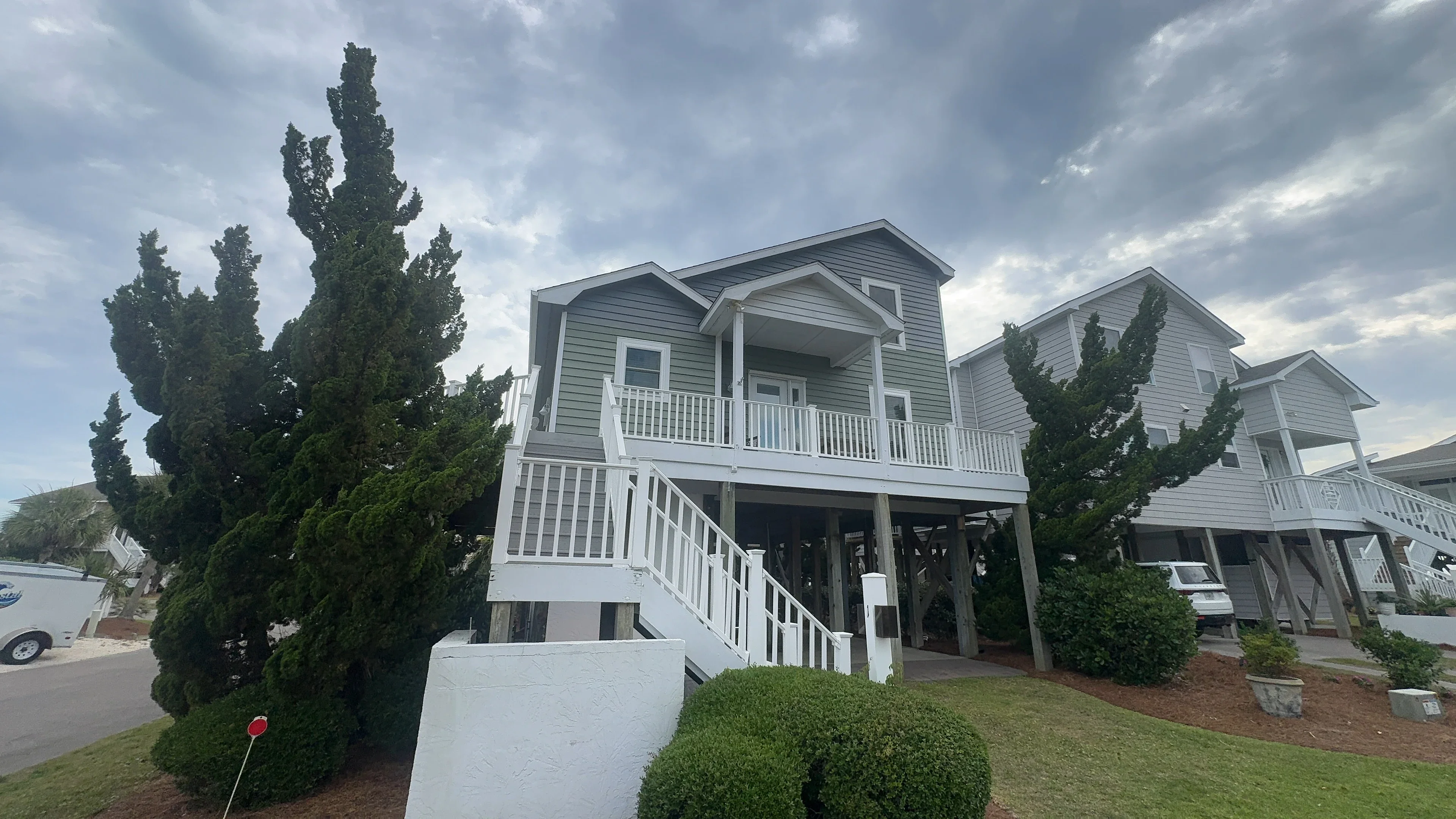 White vinyl deck railings and balusters on elevated coastal home with multiple levels