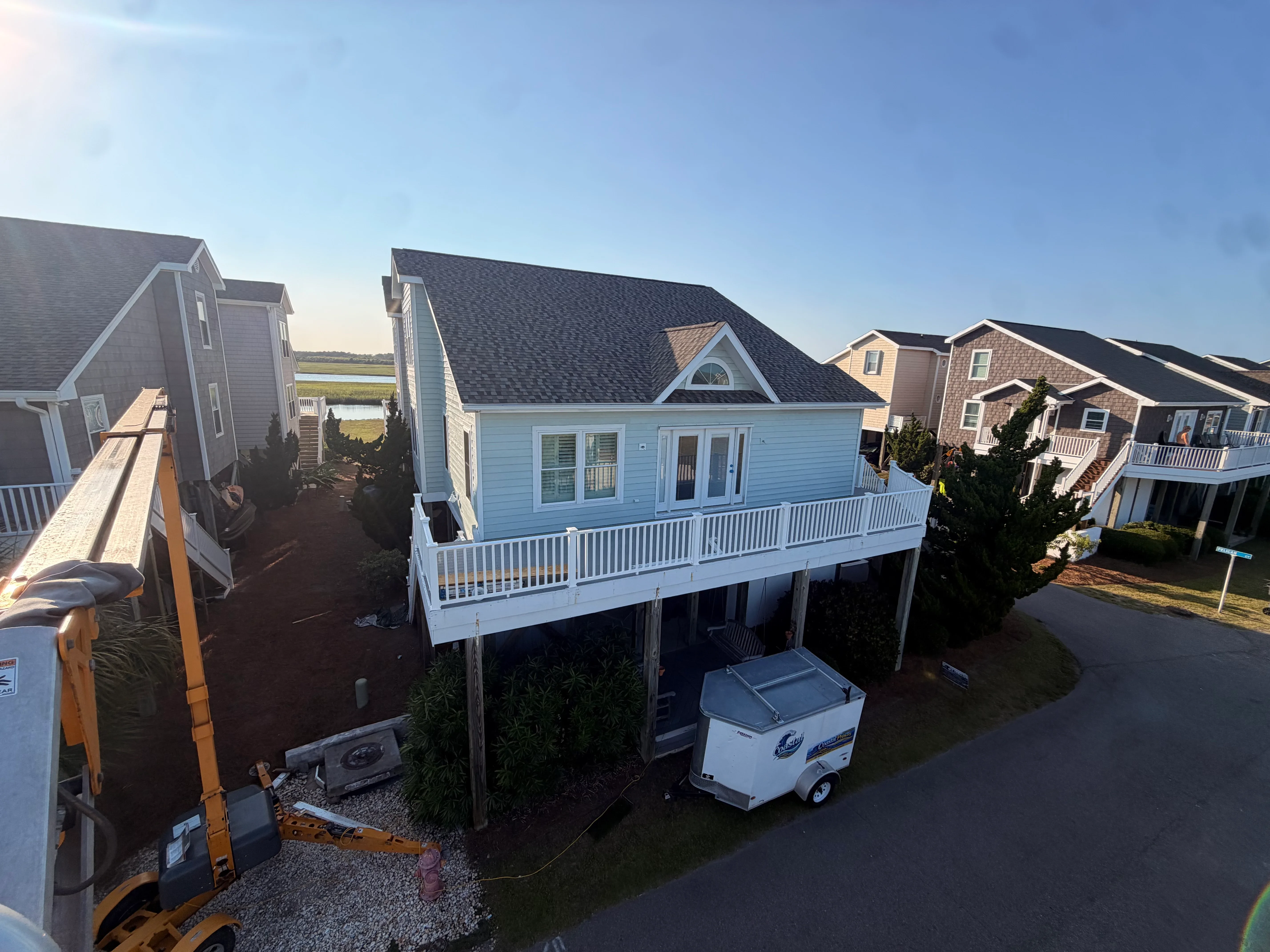 Elevated deck with white vinyl railing and balusters on coastal home