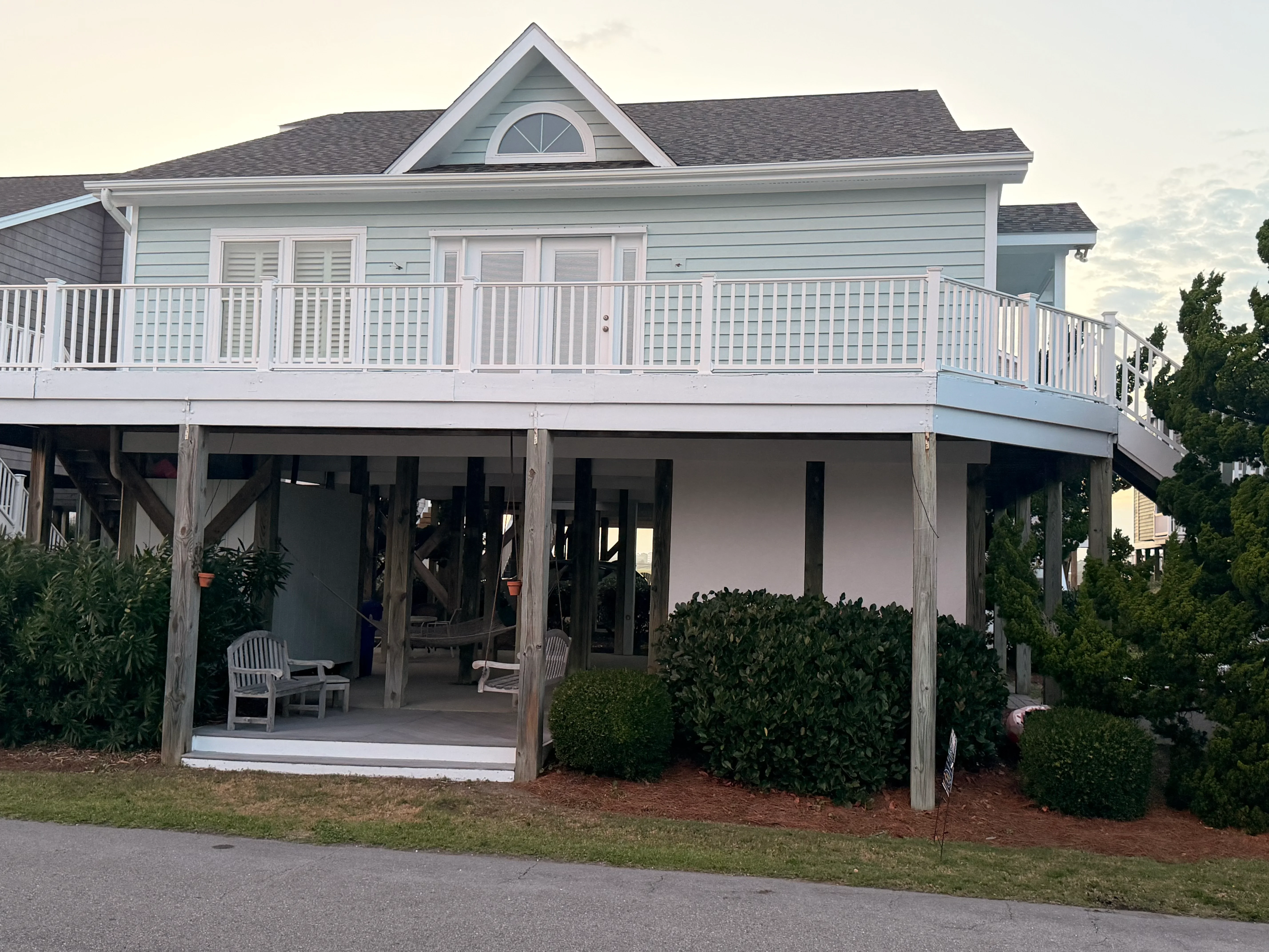 White vinyl deck railing with horizontal balusters on elevated wooden deck with support posts