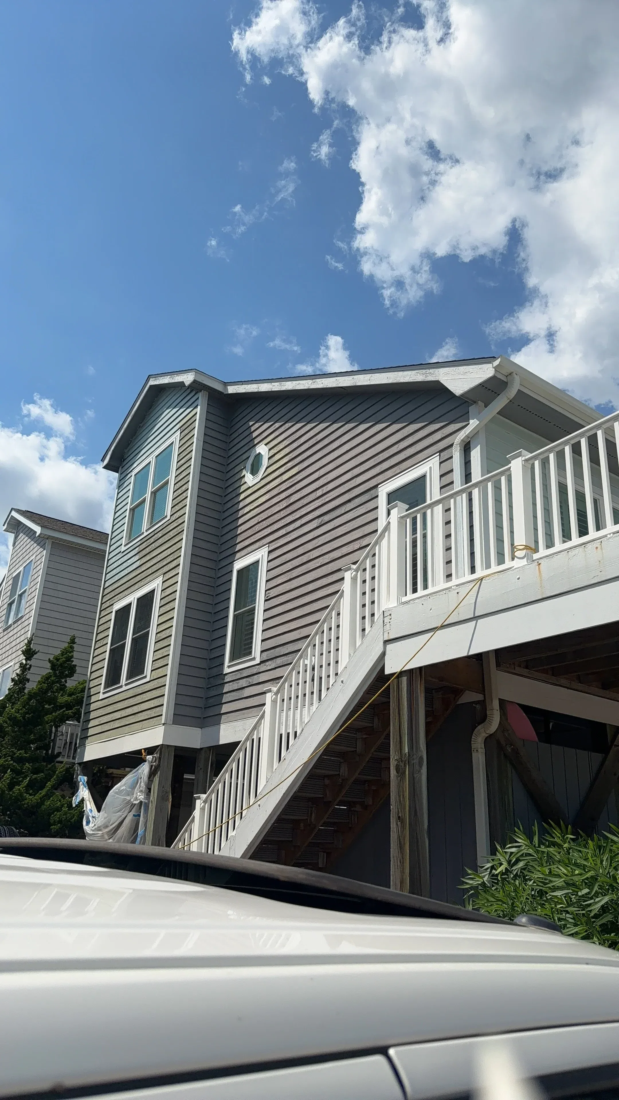 Charcoal gray standing seam metal roof with white gutters and flashing on residential home