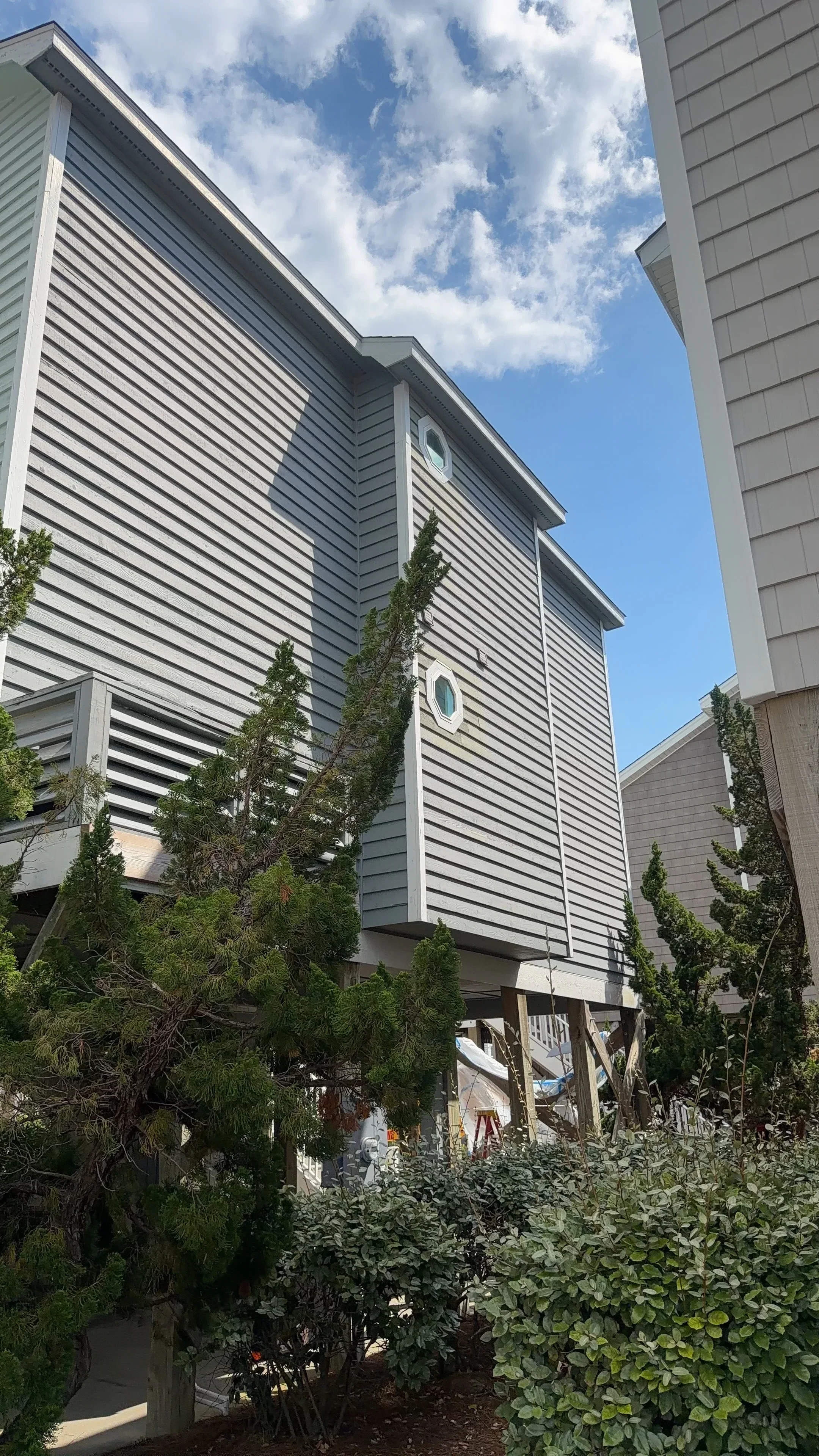Standing seam metal roof with vertical ribbed panels, gutters, and soffit installation